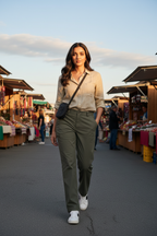 Olive green utility trousers on model at outdoor market